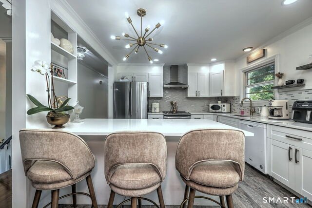 Renovated kitchen at 22 Caldwell Drive with granite counters and white cabinets